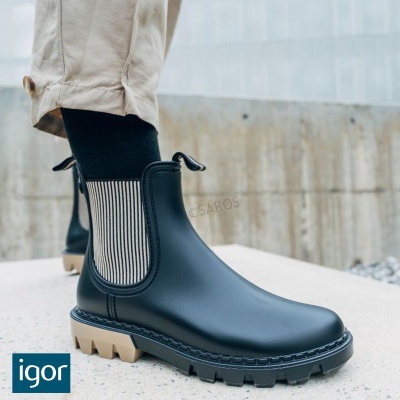 Botas impermeáveis pretas com riscas brancas e pretas no elástico lateral e sola castanha