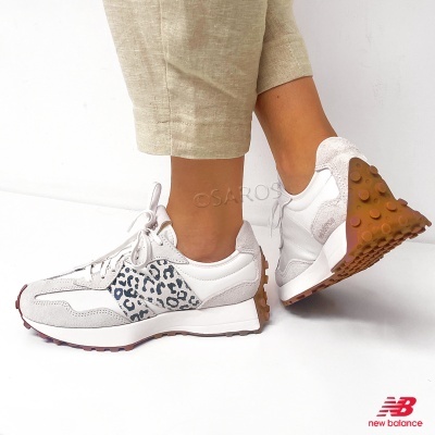Ténis New Balance brancos com detalhe leopardo cinzento e sola castanha, usados com calças bege