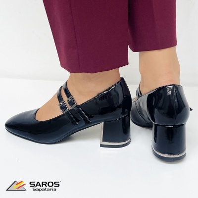 Sapatos femininos pretos em verniz com salto largo e tiras duplas, usados com calças vinho.