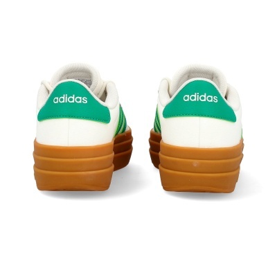 Ténis Adidas brancos com detalhes verdes e sola castanha vistos de trás