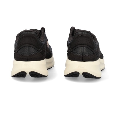 Sapatilhas desportivas pretas com sola branca vistas de trás