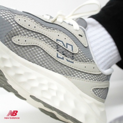 Ténis New Balance cinza com sola branca e detalhe em malha