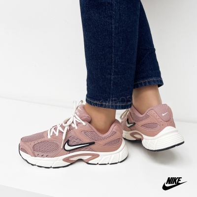 Ténis Nike rosa com sola branca e detalhes pretos usados com jeans azuis