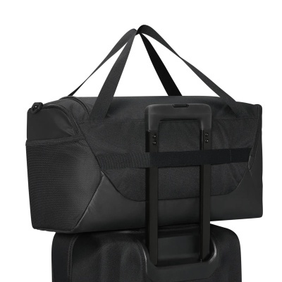 Saco de viagem preto sobre mala de rodas preta
