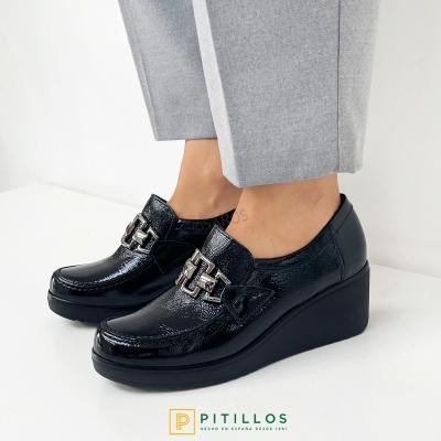 Sapatos de cunha pretos em couro verniz com fivela metálica prateada