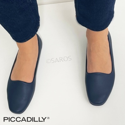 Sapatos pretos tipo bailarinas PICCADILLY usados por pessoa com calças azuis