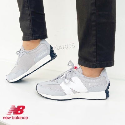 Sapatilhas New Balance cinzentas usadas num fundo branco