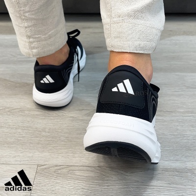 Ténis Adidas pretos com sola branca e logótipo