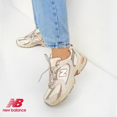 Ténis desportivos New Balance bege com detalhes castanhos e rosa em fundo branco