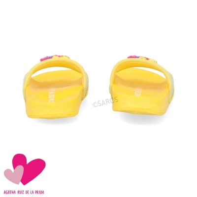 Chinelos amarelos com decoração, vistos de trás