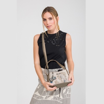 Mulher com camiseta preta, saia estampada e bolsa bege com desenho