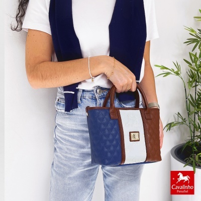 Mala de mão tricolor azul, branco e castanho com padrão acolchoado e detalhes em pele