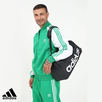 Homem com fato de treino verde e branco Adidas e bolsa preta Adidas