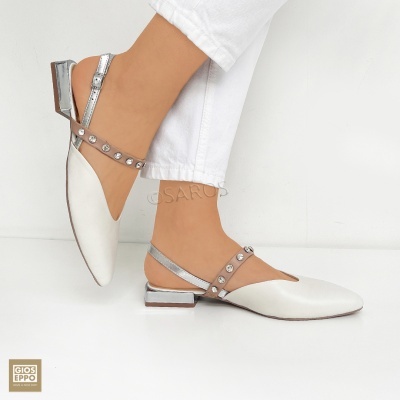 Sapatos femininos brancos e prateados com tiras e pedras em fundo branco