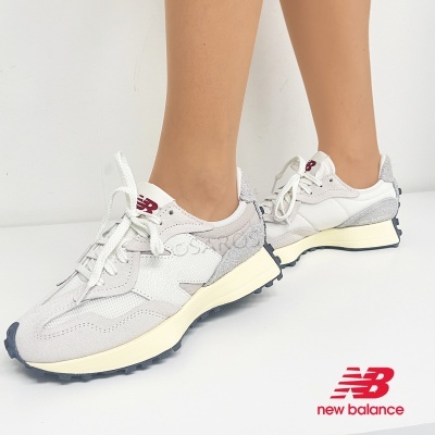 Ténis New Balance brancos e cinzentos com sola preta num fundo branco
