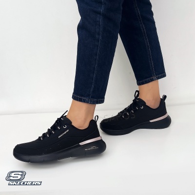 Ténis pretos Skechers com detalhes rosa claro e branco e jeans azul escuro