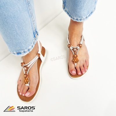Sandálias castanhas e brancas decoradas com flores usadas com calças de ganga