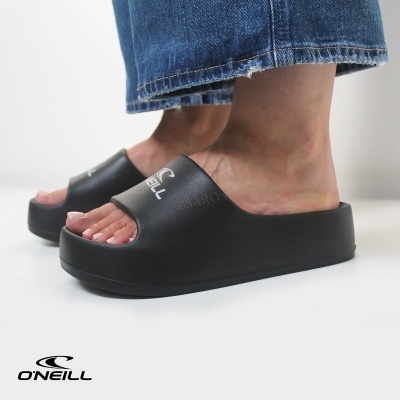 Chinelos pretos plataforma O'Neill usados por pessoa com calças de ganga