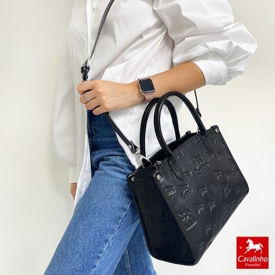 Bolsa preta Cavalinho em relevo com padrão de letras e símbolos