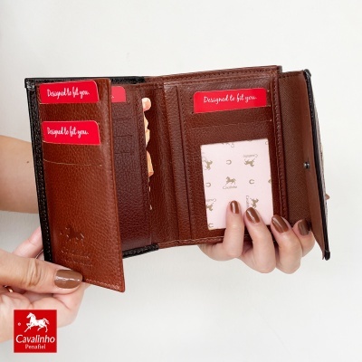 Carteira de pele castanha aberta com cartões vermelhos e logótipo Cavalinho