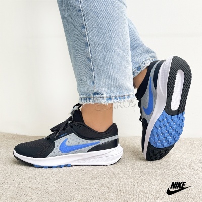 Sapatilhas Nike preto, cinzento e azul com sola branca e detalhes azuis.