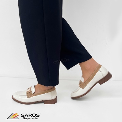 Sapatos tipo mocassim branco e bege com sola castanha e calças pretas