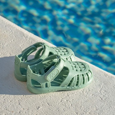 Sandálias de borracha verde água perto de piscina