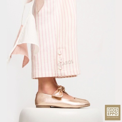 Sapato rosa metálico com laço e calças brancas riscas rosa com botões