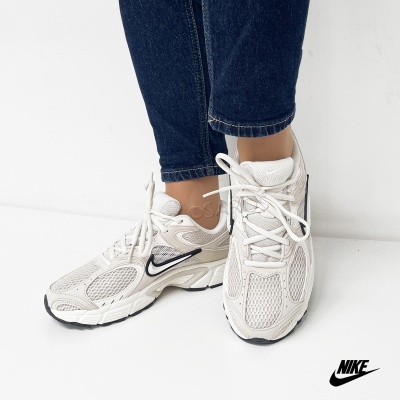 Ténis de corrida Nike bege com detalhes pretos e atacadores brancos