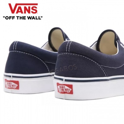 Sapatos Vans azul escuro com sola branca e etiquetas vermelhas e brancas na parte de trás