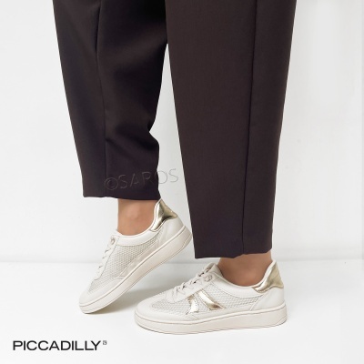 Sapatos desportivos brancos com detalhes dourados e calças pretas num fundo branco