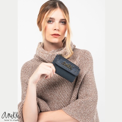Mulher a segurar uma carteira preta de pele com fecho dourado e inscrição Anekke
