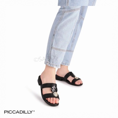 Sandálias rasas pretas com detalhe metálico e calças de ganga azuis claras.