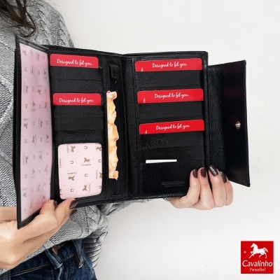 Carteira preta de pele aberta com vários compartimentos e cartões vermelhos 'Designed to fit you'