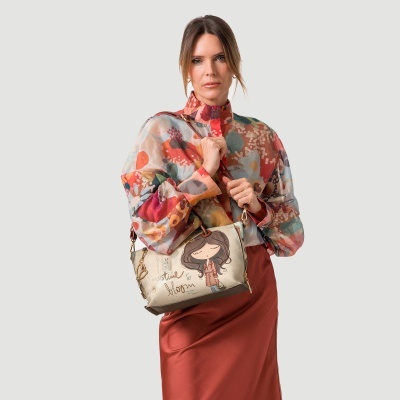 Mulher com blusa colorida e mala bege com ilustração e texto