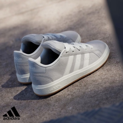 Sapatilhas Adidas cinza claro com detalhes brancos sobre superfície cinza