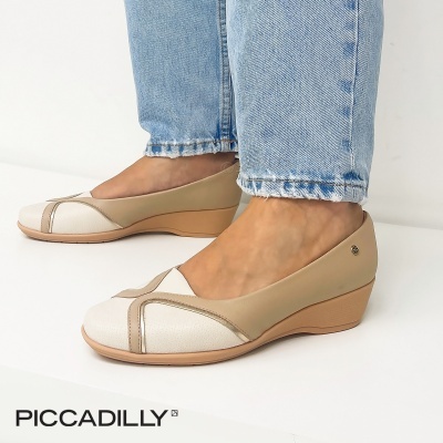 Sapatilhas de cunha bege claro com detalhes brancos usadas com jeans azul claro