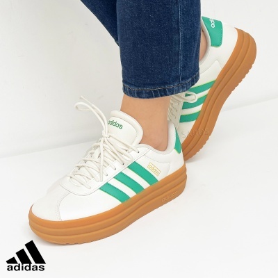 Sapatilhas Adidas brancas com riscas verdes e sola castanha