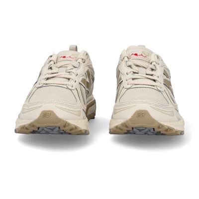 Sapatilhas New Balance bege com detalhes dourados e etiqueta 410v5 em vista frontal.