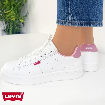 Ténis brancos com detalhes rosa e logo Levi's usados com calças de ganga