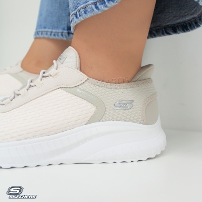 Ténis Skechers bege claro com sola branca usados com calças de ganga