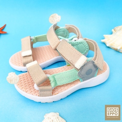 Sandálias infantis bege e verde com solado branco e conchas decorativas