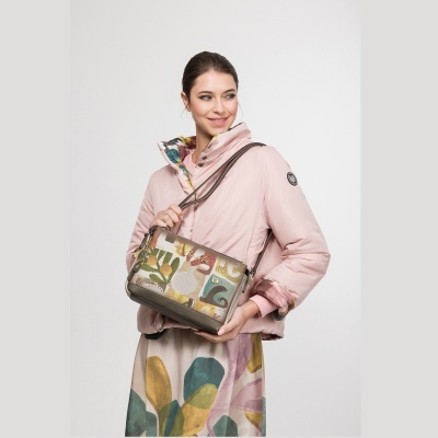 Mulher com casaco rosa e mala colorida abstrata em fundo branco