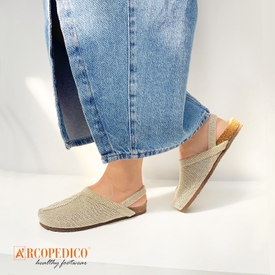 Sapatos tipo sabrinas bege em fundo branco com calças de ganga e logo Arcopecido