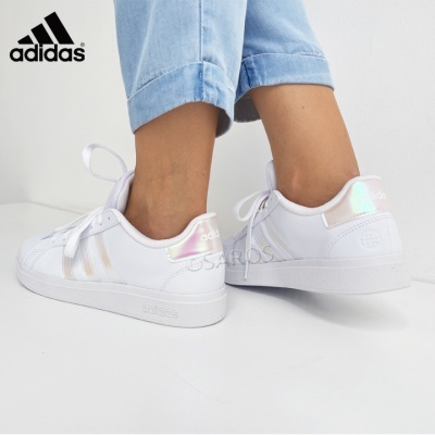 Ténis Adidas brancos com detalhes iridescentes usados com calças de ganga azuis claras