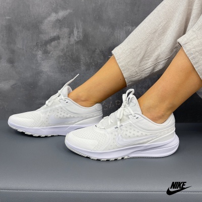 Ténis desportivos brancos da Nike com padrão de estrelas e sola grossa
