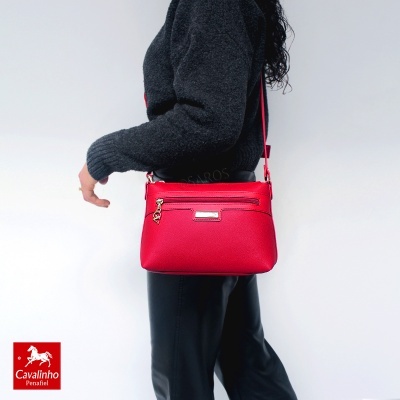 Mala vermelha de mulher com fecho dourado usada ao ombro