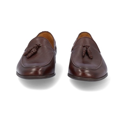 Sapatos de pele castanha com tasséis sobre fundo branco