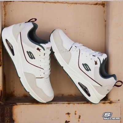 Sapatilhas brancas Skechers com detalhes em bege, cinza e bordô em superfície metálica envelhecida