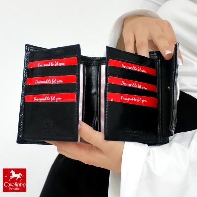 Carteira preta de couro com múltiplos compartimentos aberta mostrada por mãos femininas